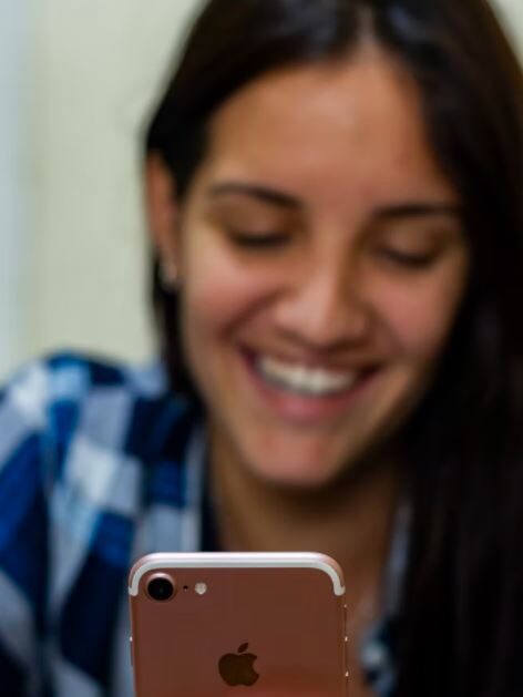 woman smiling front of a smartphone