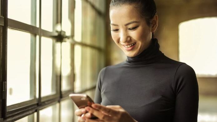 a woman smiling with a smartphone