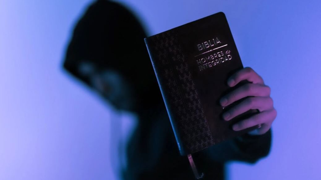 Person holding a Bible with a blurred background.