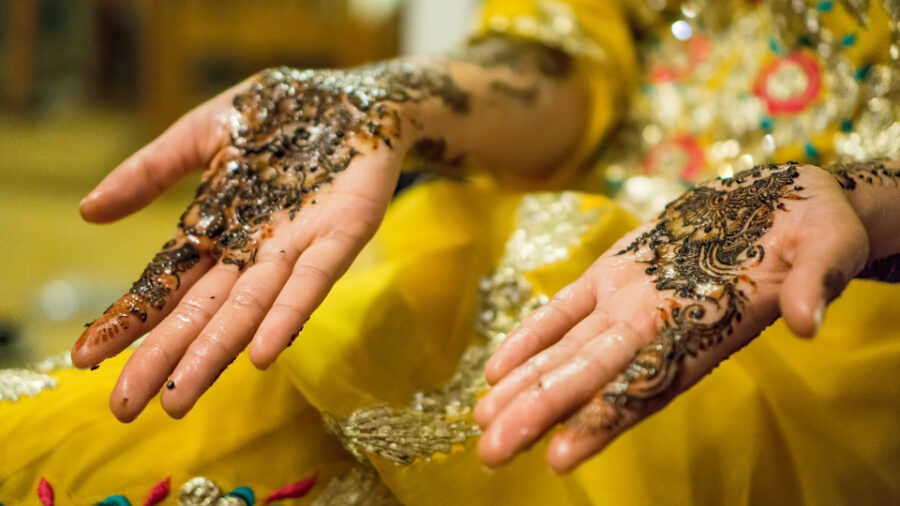 Hands with detailed henna patterns, symbolizing cultural celebration, held open with palms facing up.