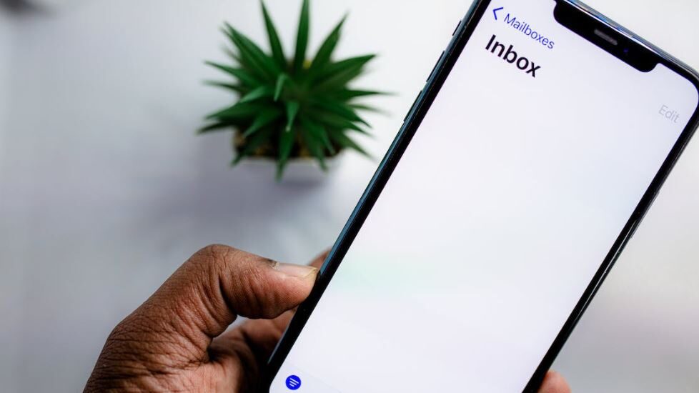 Image of a smartphone screen with an empty email inbox, emphasizing a moment of waiting or silence.