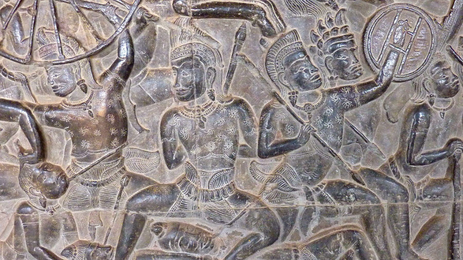 Stone relief depicting warriors from the Mahabharata at Angkor Wat, featuring detailed ancient carvings.