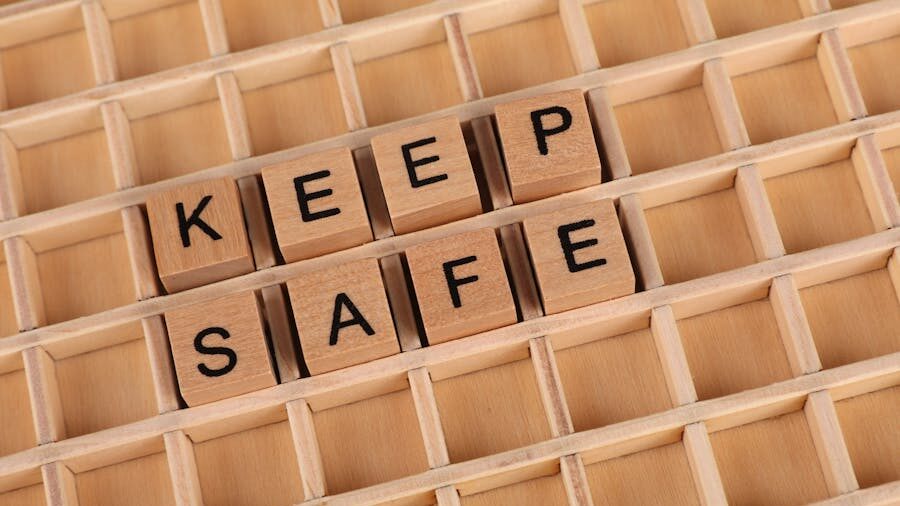 Wooden letter tiles spelling "KEEP SAFE" arranged on a wooden grid.