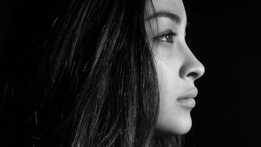 Black and white profile portrait of a woman with long hair, gazing into the distance.