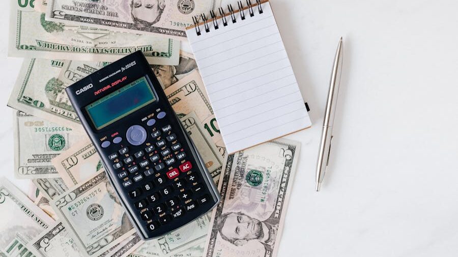 A scientific calculator, a notepad, and a pen placed on top of scattered US dollar bills.