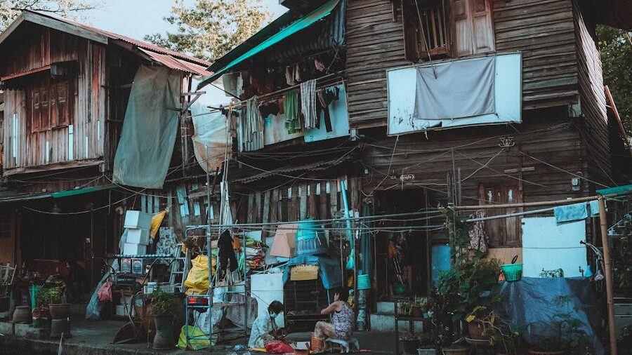 Traditional wooden stilt houses with laundry hanging outside and people engaged in daily activities.