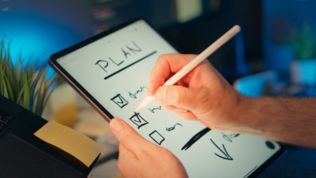 Digital checklist being written on a tablet with a white stylus in a cozy workspace setup.