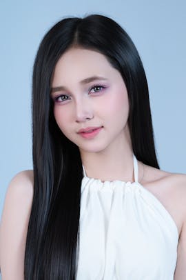 Studio-style portrait of a woman with long dark hair, gentle lighting, and a composed facial expression.