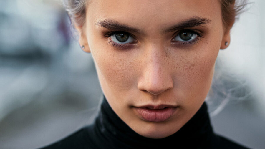 Portrait d'une femme à l'expression sérieuse et au regard captivant, créant une atmosphère puissante et intime.